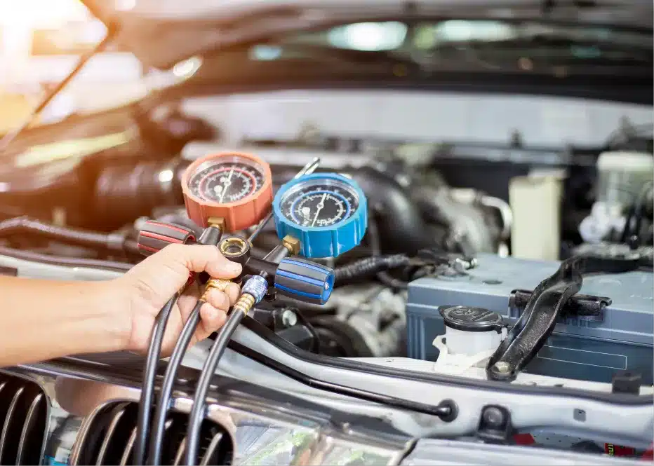 Auto a/c and heater repair in St. Charles, IL by Precision Motorworks. Image of a mechanic using A/C pressure gauges under the hood, highlighting the shop’s commitment to reliable cooling system service and driver comfort.