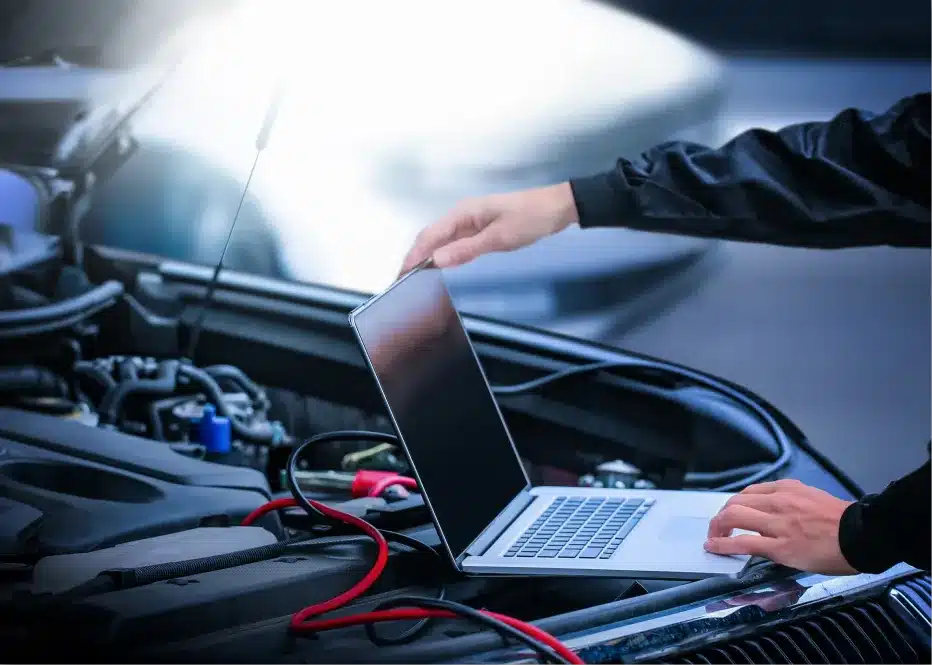 vehicle diagnostics in St. Charles, IL by Precision Motorworks. Image of a technician using a laptop connected to a car’s engine bay for advanced vehicle diagnostics and testing.