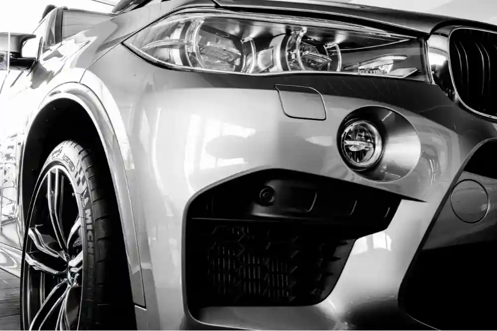 Image of a close-up BMW front end with premium tires and headlights, showcasing attention to detail in European auto repair and maintenance.