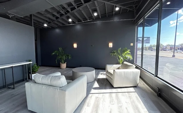 a room with white furniture and plants