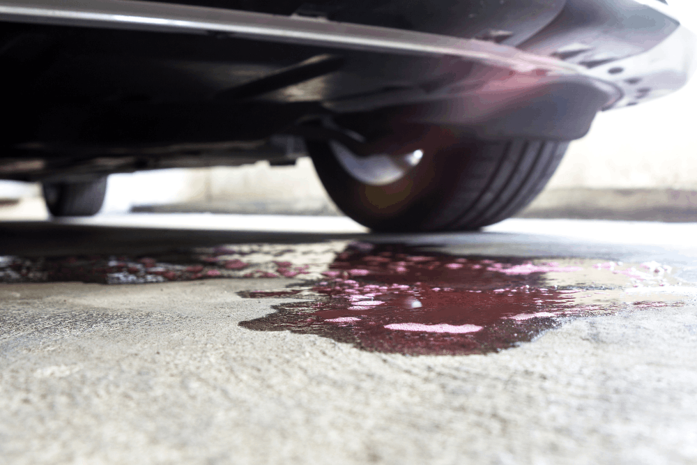Cooling upgrade, auto repair in St. Charles, IL, at Precision Motorworks. Image of coolant leaking beneath a vehicle, highlighting expert cooling system diagnostics and repairs that help prevent engine overheating and keep your vehicle running safely and reliably.
